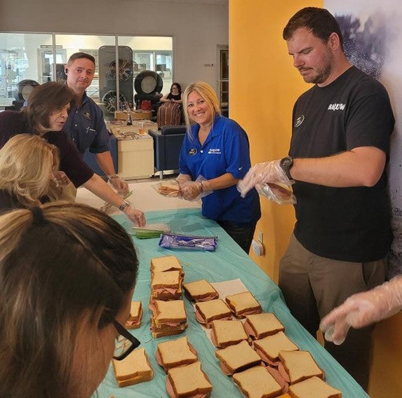 Volunteer bagging sandwiches for fundraiser event